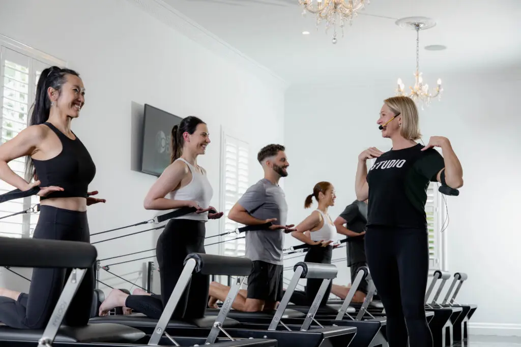 Studio Pilates instructor teaching Studio Pilates reformer Pilates class