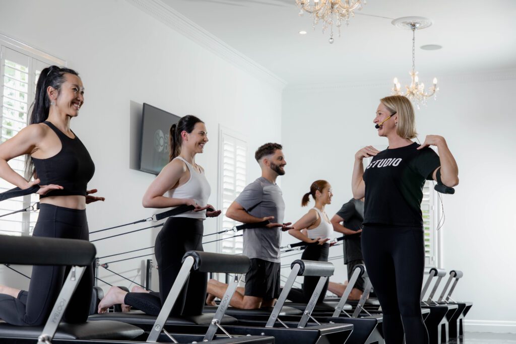 Studio Pilates instructor teaching Studio Pilates reformer Pilates class